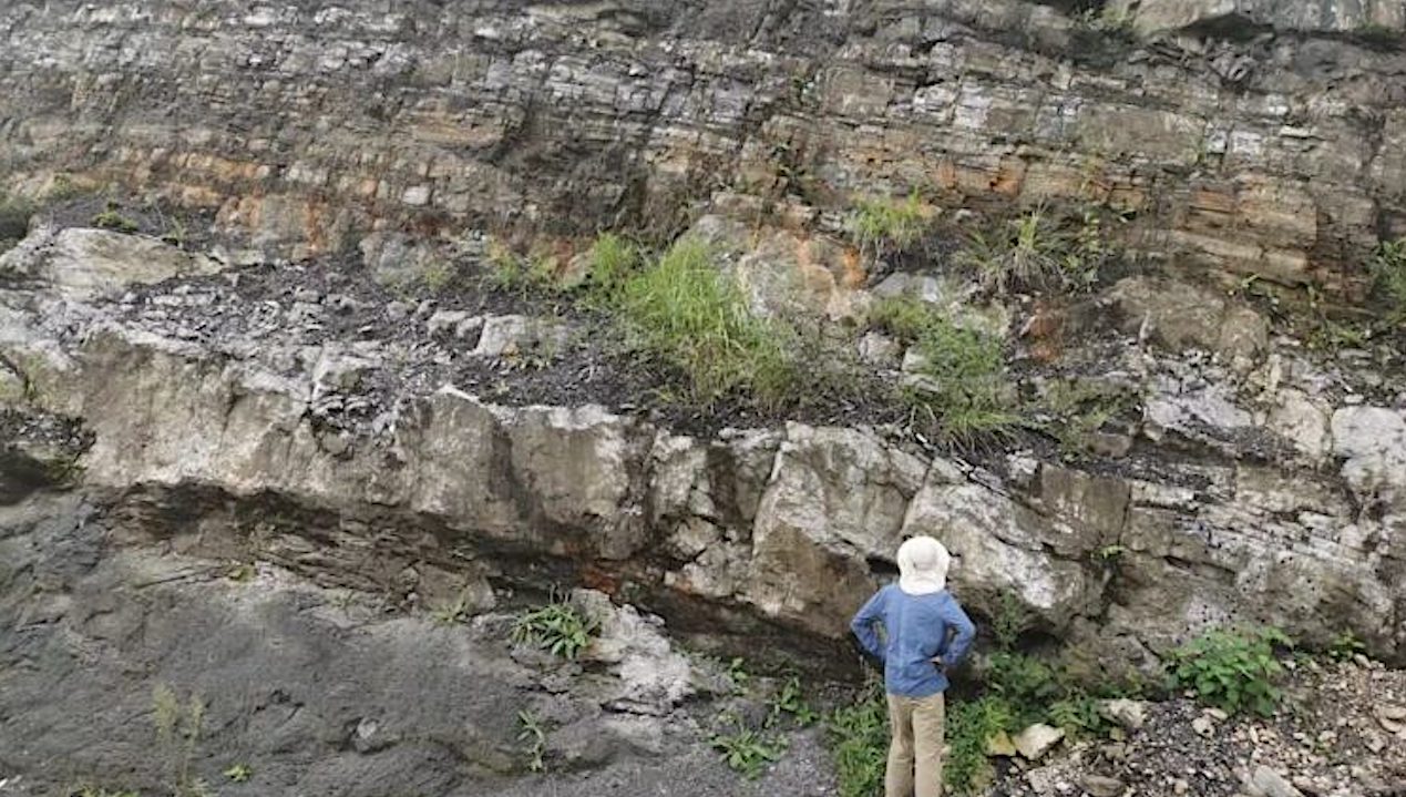 A person looks at cap carbonate rocks in South China in 2019. The new study provides a new explanation for dramatic global environmental changes that led to their formation. Credit Yarong Liu