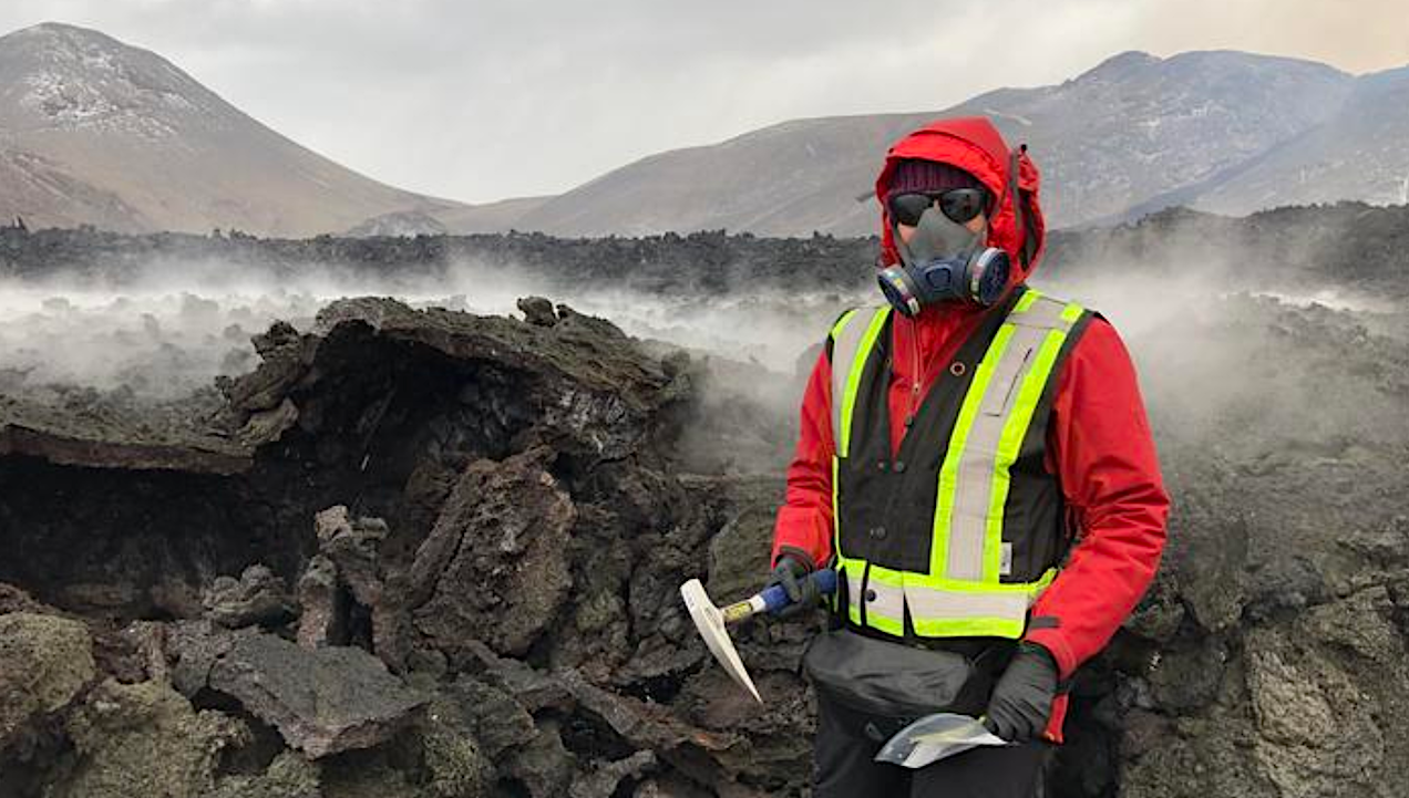 Wearing protective gear against toxic gases, Solange Duhamel stands next to a lava flow during an outing to collect samples of freshly deposited lava rock. Credit Christopher Hamilton