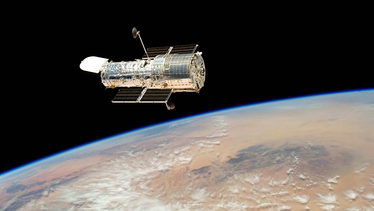 Hubble drifts over Earth after its release on 19 May 2009 by the crew of the Space Shuttle Atlantis. The crew had performed all planned tasks over the course of five spacewalks, making the Servicing Mission 4, the fifth astronaut visit to the Hubble Space Telescope, an unqualified success. Credit: NASA/ESA larger image