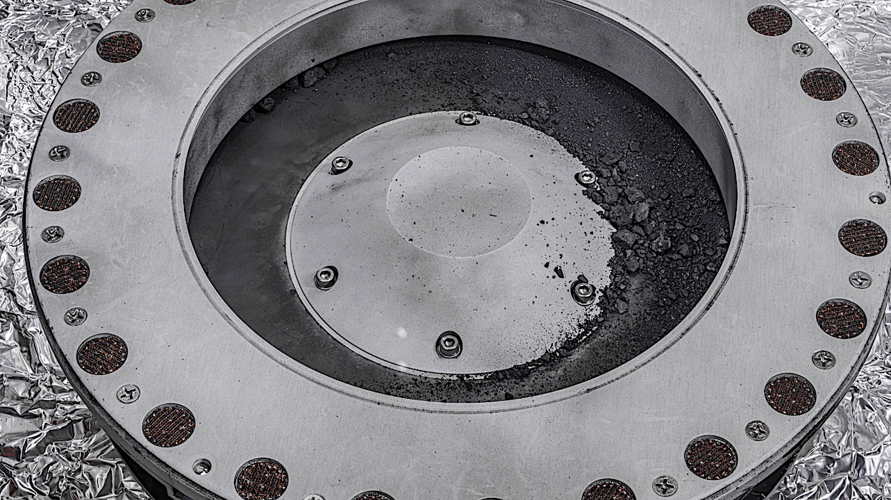 A view of the outside of the OSIRIS-REx sample collector. Sample material from asteroid Bennu can be seen on the middle right. Scientists have found evidence of both carbon and water in initial analysis of this material. The bulk of the sample is located inside. Photo: NASA/Erika Blumenfeld & Joseph Aebersold